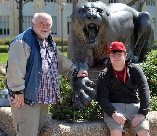 Dad and son are glad the fierce cougar is just a statue!