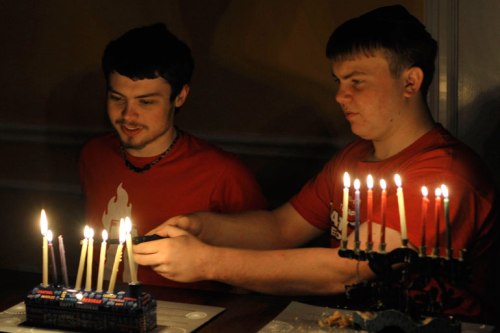 Younger helps older keep his candles lit