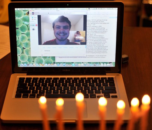 My older son smiles via Skype as the sixth-night candles glow.