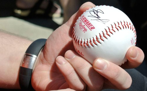 C.J. holds the ball with his first autograph.